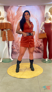 Mulher com vestido curto terracota, cinto preto de tachas e botas.